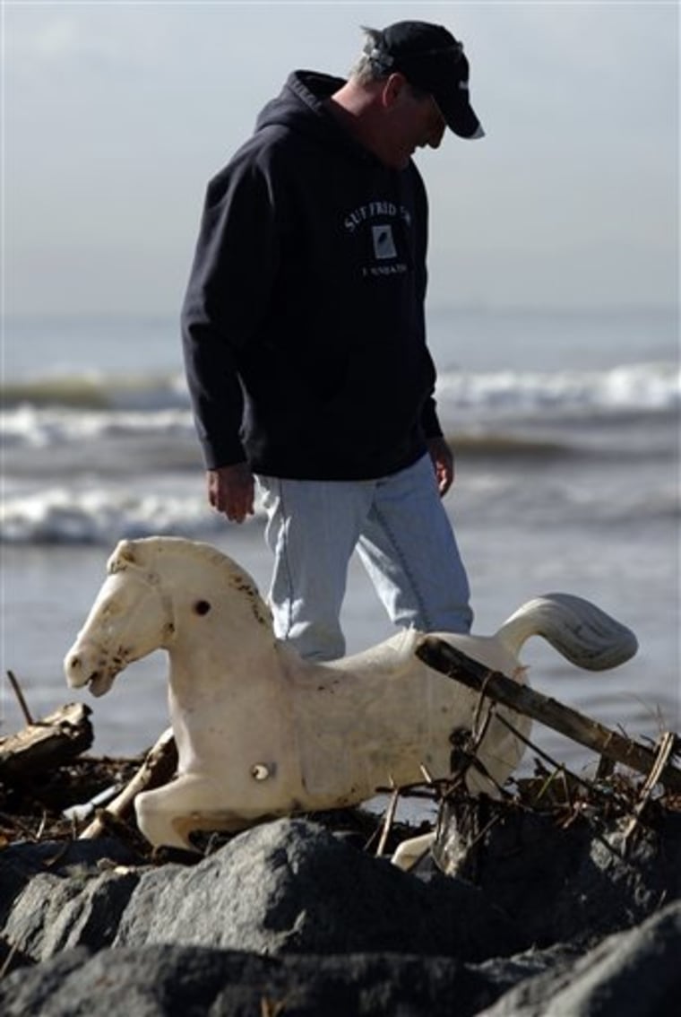 Steve Masoner, co-fonder of the non-profit Save Our Beach, looks for more trash after pulling a plastic rocking horse from the rocks along the San Gabriel River after a storms washed up garbage and other debris in Seal Beach, Calif. on Saturday, Jan. 23, 2010. (AP Photo/Jason Redmond)